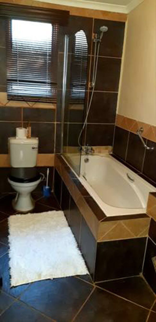A bathroom with a toilet, a bathtub, and a shower.