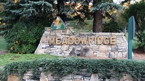 Un mur de pierres sur lequel on peut lire, en grandes lettres, le mot « MEADOWRIDGE ».