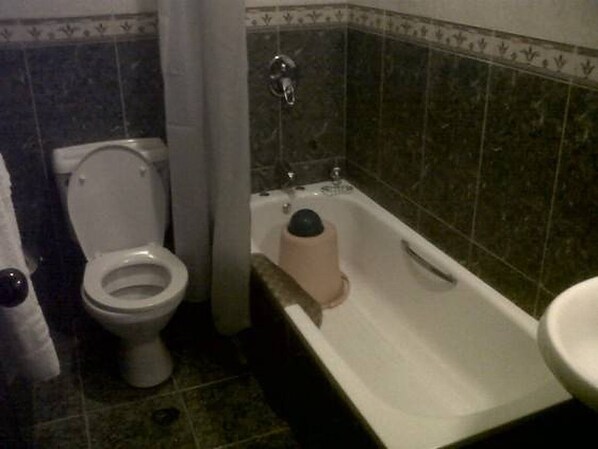 A bathroom with a toilet, a bathtub, and a sink. - Grand Valley Hotel (Abuja)