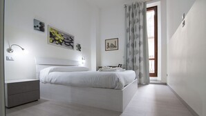 A modern bedroom with a large bed, bedside tables, and artwork on the walls. - Appartamento in Piazza Bra con balcone (Verona)