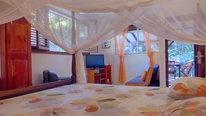 A bedroom with a bed, a television, and a desk.
