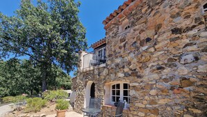A stone building with a balcony, outdoor seating, and a garden. - Hameau des Claudins # 2 Préconil with heated swimming pool near Saint-Tropez (Le Plan-De-La-Tour)