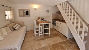A compact living space with a kitchenette, a dining area, and a staircase. - Hameau des Claudins # 2 Préconil with heated swimming pool near Saint-Tropez (Le Plan-De-La-Tour)