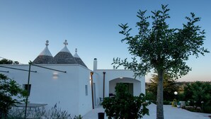 Un edificio blanco con un diseño arquitectónico único, que presenta techos cónicos y una pared de piedra.