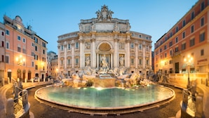 Une magnifique fontaine ornée de statues, avec une statue centrale, le tout intégré dans un ensemble d’architecture classique.