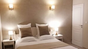 A bedroom with a large bed, two bedside tables, and a door.