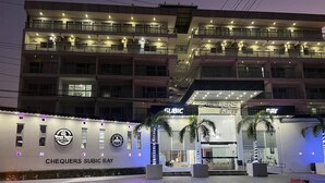 Un hotel con varios pisos, balcones y unidades de aire acondicionado. El nombre del hotel es visible en la señalización.