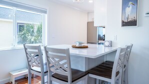 Una cocina moderna con armarios blancos, horno integrado y un amplio ventanal que proporciona luz natural.