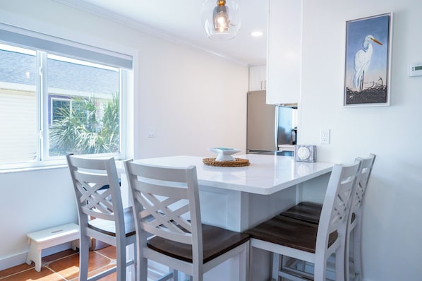 A modern kitchen with white cabinetry, a built-in oven, and a large window providing natural light.