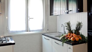 A kitchen with white cabinets, a black countertop, and a window with sheer curtains. - Marvelous apartment in the center of Rome 100 meters from the Vatican Free Wifi (Roma)