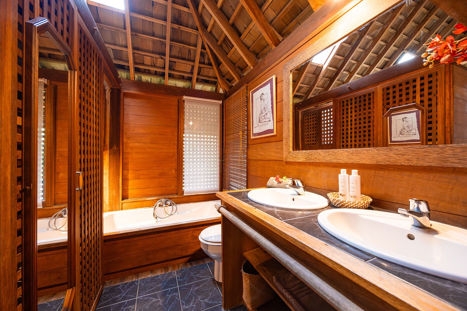 Une salle de bain en bois avec deux lavabos, des toilettes et un espace douche.