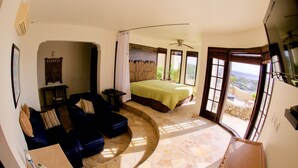 A bedroom with a bed, a sofa, a TV, and a balcony with a view. - SERENDIPITY ocean views Villa Serenity & Villa Serenade A Unique Island Escape.  (Upper Prince's Quarter)