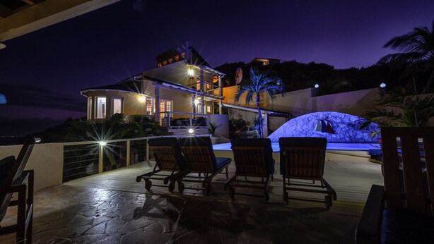 A patio area with outdoor seating and a view of a house. - SERENDIPITY ocean views Villa Serenity & Villa Serenade A Unique Island Escape.  (Upper Prince's Quarter)