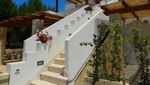 Eine weiße Treppe mit Holzgeländern und Blumentöpfen.