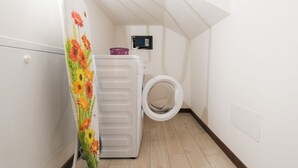 A laundry room with a washing machine, a dryer, and a wall-mounted control panel. - Ampio alloggio con due camere da letto (Verona)