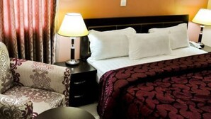Une chambre d’hôtel avec un lit, deux lampes de chevet, une chaise et une table de chevet.