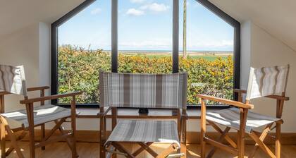 Nykyaikainen irrotettu neljän makuuhuoneen navetta muuntaminen sijaitsee aivan Norfolkin rannikolla Titchwellissa. Se on erittäin tilava ja erittäin mukava.<br>Sinulla on upeat näkymät merelle merelle laiturilta, etenkin kaukoputken kautta!