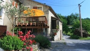 A rustic stone building with a wooden balcony and potted plants. - Parsley Holiday Home, Tarn, South West of France (Cambounès)
