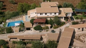 Vue aérienne d’un quartier résidentiel avec de nombreuses maisons, une piscine et de la végétation luxuriante tout autour.