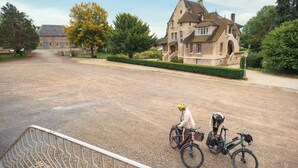 Un grand bâtiment en pierre, doté d’une entrée imposante et d’une allée menant à celui-ci.
