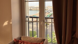 Une chambre avec vue sur un port de plaisance et sur des bateaux.