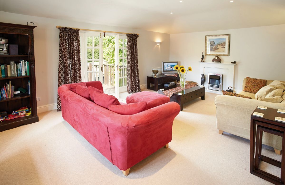 Principal sitting room on the first floor with French doors opening onto a deck overlooking the garden