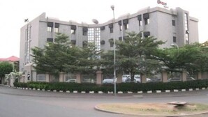 A modern building with a flat roof, multiple windows, and a sign that reads "Hotel". - Nugget Hotel (Abuja)