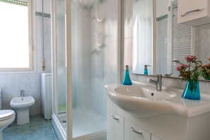 Een douche, een haardroger, een bidet, handdoeken