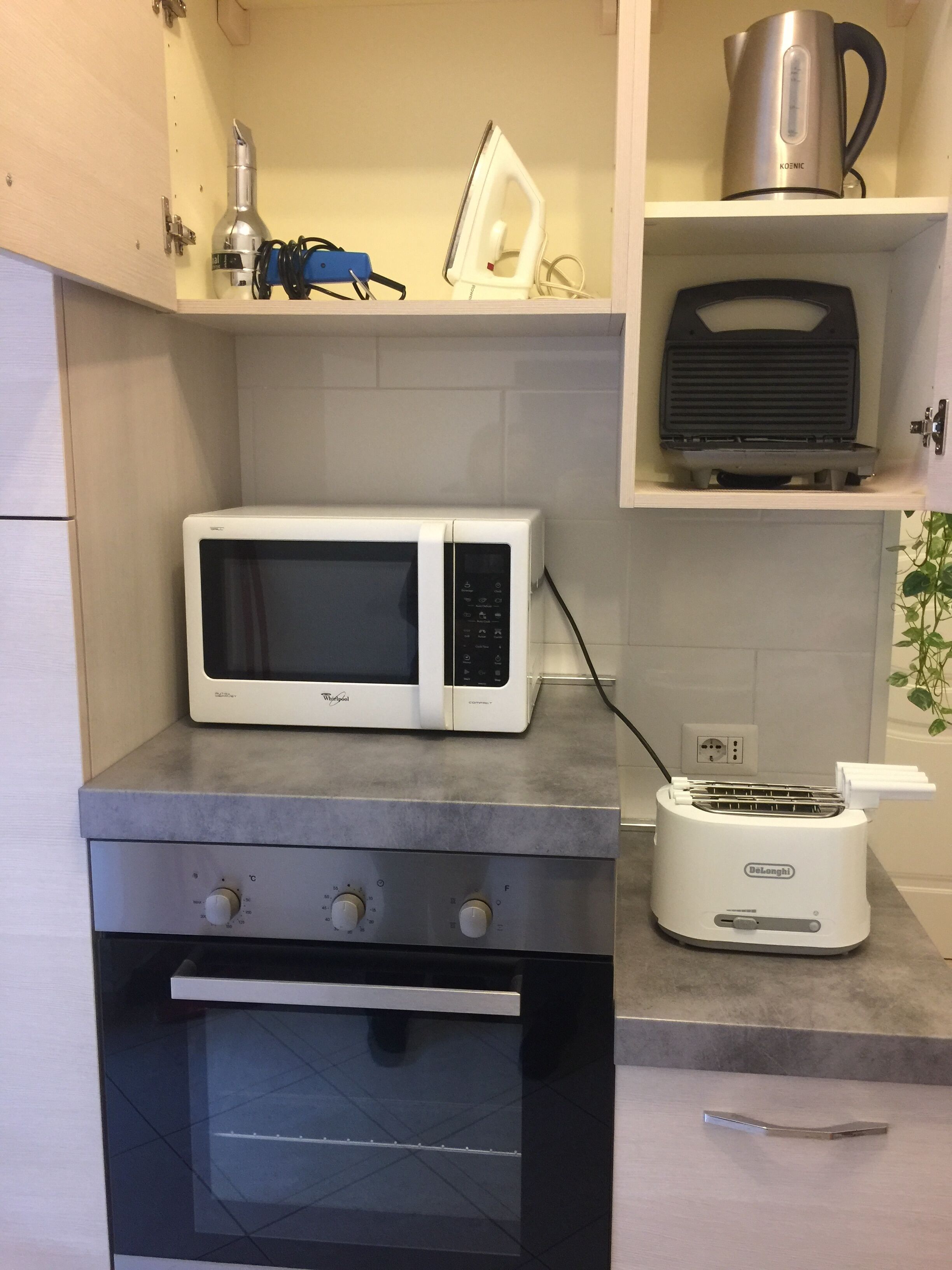 Una cocina compacta equipada con microondas, tostadora y horno.