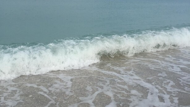 Une plage où les vagues se brisent près du rivage.
