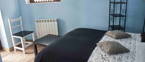 Une chambre à coucher avec un lit, une chaise, un radiateur et une fenêtre.