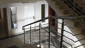 Un intérieur à plusieurs niveaux, avec un escalier, une porte et une fenêtre.
