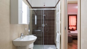 Une salle de bain moderne avec une douche à parois de verre, un lavabo et un miroir.