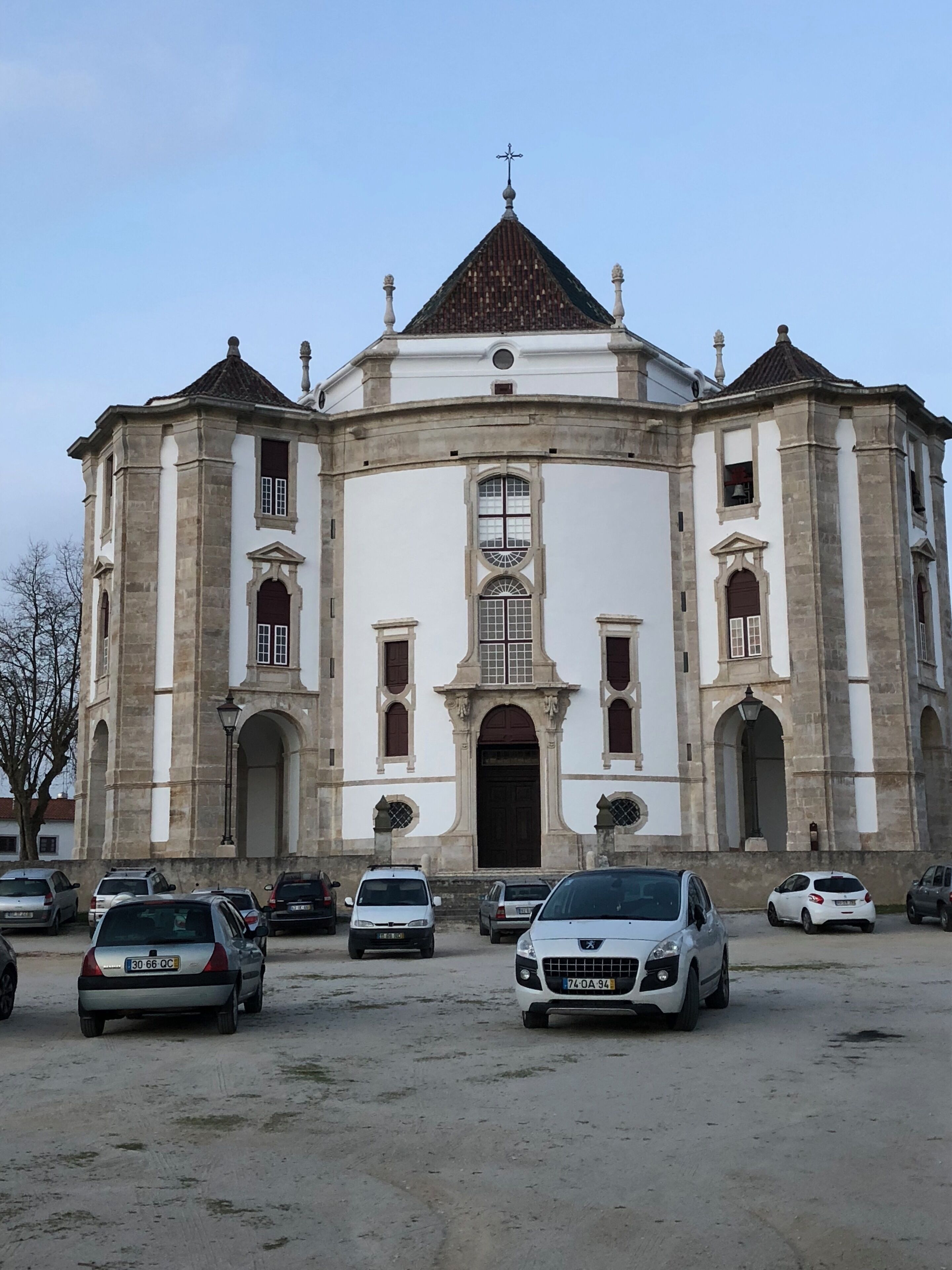 Un grand bâtiment historique à la façade symétrique, doté de nombreuses fenêtres en arc de cercle et d’une entrée centrale.