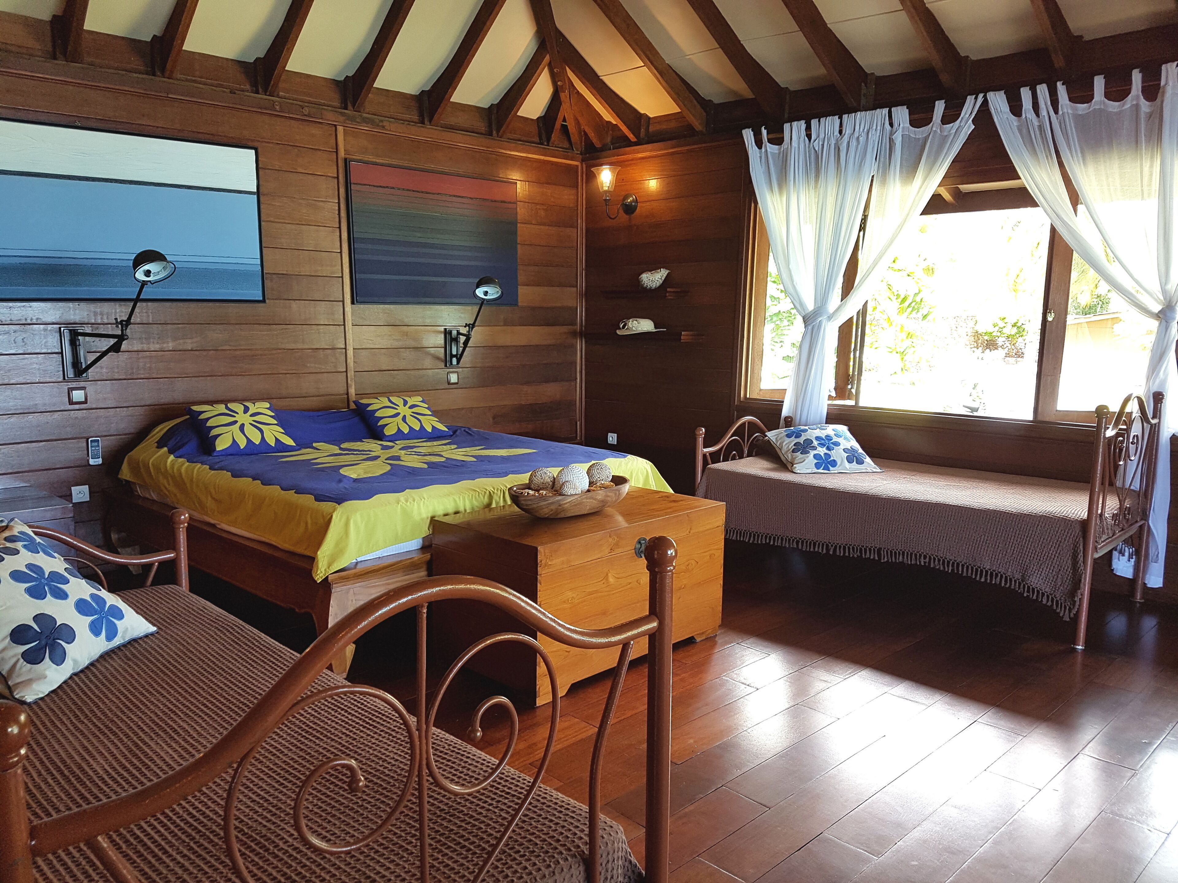 A wooden cabin with two beds, a dining area, and a view of the outdoors.