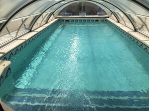 A swimming pool with a tiled edge and a canopy overhead. - New Ad - Charming quiet house, air conditioning, shared pool (Châteaurenard)