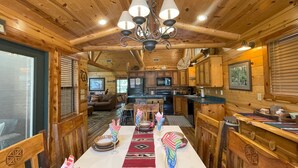 L’intérieur d’une cabane en bois comprend un coin repas, une cuisine et un salon.