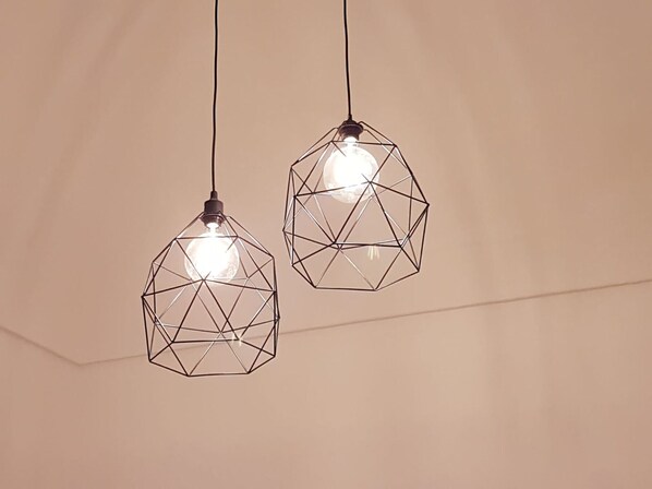 Two geometric pendant lights with exposed bulbs hanging from the ceiling.