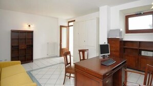 A room with a wooden desk, two chairs, a television, and a bookshelf. - RAVELLO "Nonna Anna" AMALFI COAST (RAVELLO)