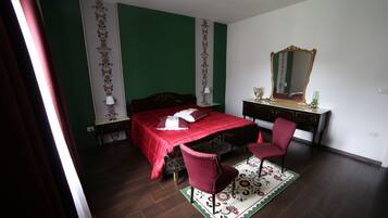 Een slaapkamer met een bed, een stoel, een kapstok en een spiegel.