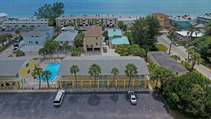 A coastal hotel with multiple buildings, a swimming pool, and a view of the ocean.