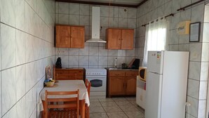 A compact kitchen with wooden cabinets, a stove, a microwave, and a refrigerator. - Verval T1 floor "Furnished with Tourime 3 *** (Unknown)