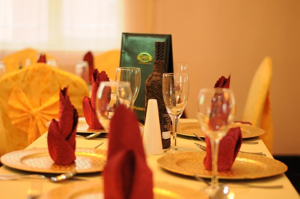 A table set for dining with a menu, wine bottle, and glasses.