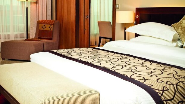 Een hotelkamer met een groot bed, een bank, een stoel en een bureau.