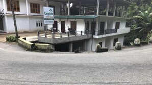 A guest house named Canalside with a signboard, a balcony, and a motorcycle parked outside. - Canalside Villa & Guest House (Ginigathena)