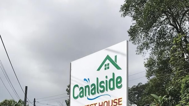 A sign for Canalside Guest House advertising amenities like WiFi, a bed, and a dining area. - Canalside Villa & Guest House (Ginigathena)
