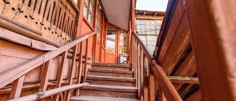 Staircase leads to upper levels, flanked by railings and a window.
