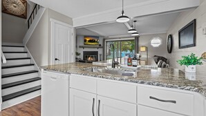 A kitchen with a granite countertop, white cabinets, a dishwasher, and a ceiling fan. - Izaty's Beach Villa- Completely remodeled and exceptionally clean (Onamia)