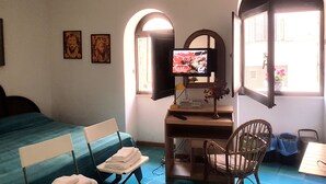 A hotel room with a bed, a desk with a computer, a chair, and a TV. - THE PANATICS Studio apartment (Gaeta, Italia)