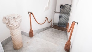 A marble staircase with a rope barrier, a metal gate, and a classical sculpture. - THE PANATICS Studio apartment (Gaeta, Italia)